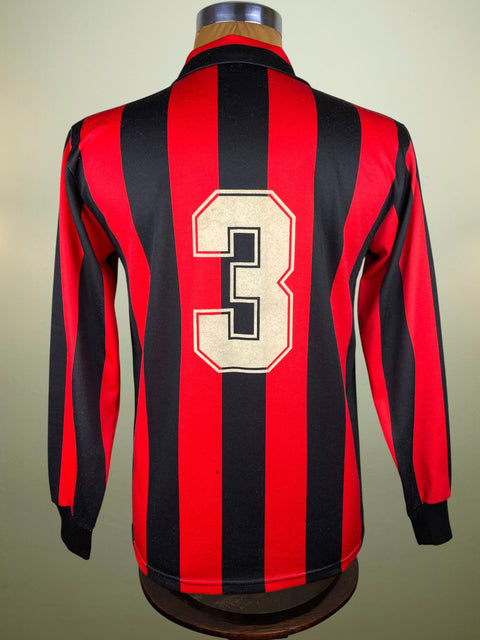 Red and black striped AC Milan jersey with number 3 on a mannequin against a beige background