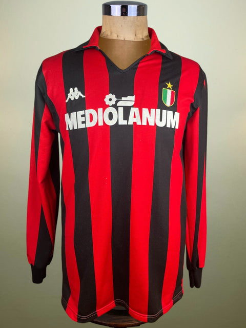 Red and black striped 1988 AC Milan home jersey with 'Mediolanum' and kappa logo on a mannequin against a neutral background