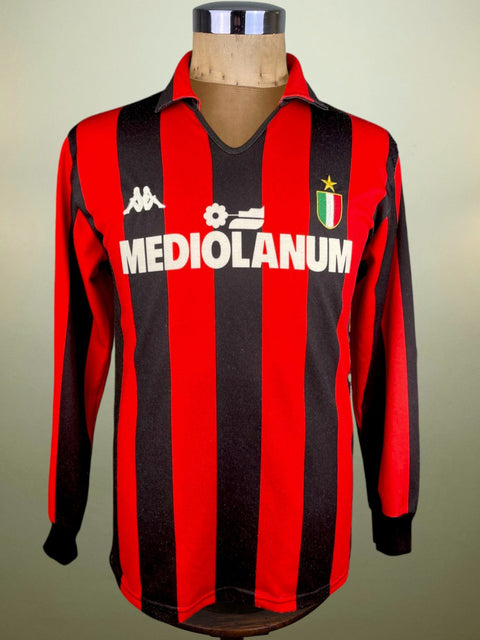 A red and black striped AC Milan soccer jersey from the 1988 season, displayed on a mannequin.