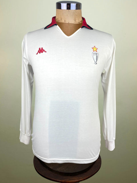 White long-sleeve 1989 AC Milan Intercontinental Cup jersey on a mannequin against a beige background