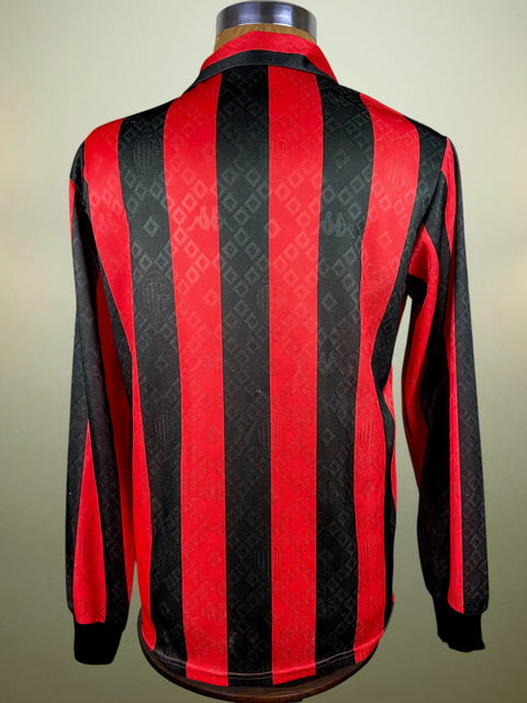 Red and black AC Milan shirt on a mannequin against a neutral background