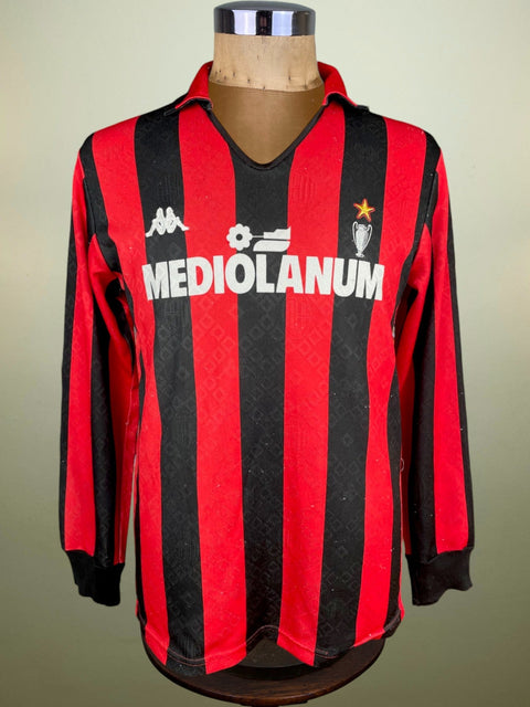 Red and black striped AC Milan 1989 jersey with 'Mediolanum' branding on a mannequin against a beige background