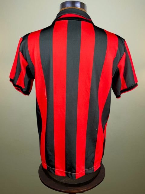 Red and black striped AC Milan 1990 home on a mannequin against a plain background