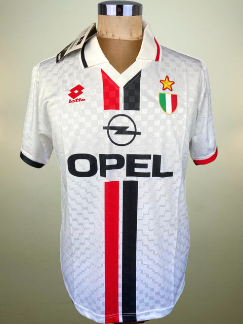 A vintage AC Milan soccer jersey by Lotto, featuring a white patterned body with red and black vertical stripes, the black Opel logo, and the Italian club crest on the chest, displayed on a mannequin.