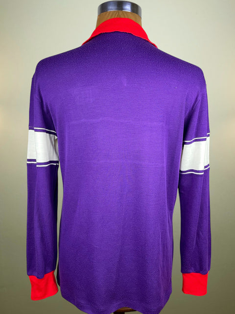 Purple long-sleeve shirt with red and white accents on a mannequin against a beige background