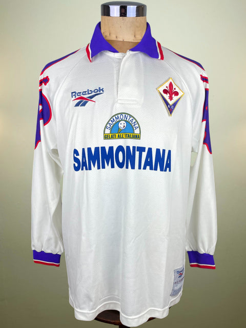 White Fiorentina Away jersey with blue and red accents and Sammontana Sponsor across the chest on a mannequin against a neutral background