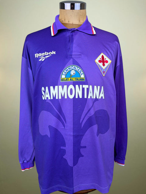 A vintage purple Reebok long-sleeve Fiorentina soccer jersey displayed on a wooden mannequin torso. The jersey features the white 'SAMMONTANA' sponsor logo across the chest, the Fiorentina club crest on the left chest, and the Reebok logo on the right chest.