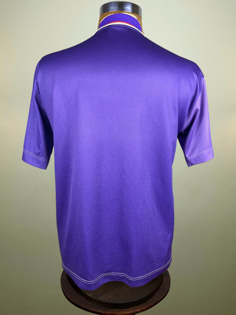 Purple polo shirt on a mannequin against a beige background