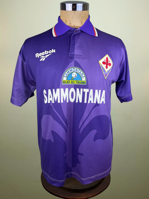 Purple Fiorentina jersey with Reebok and Sammontana logos on a mannequin against a beige background
