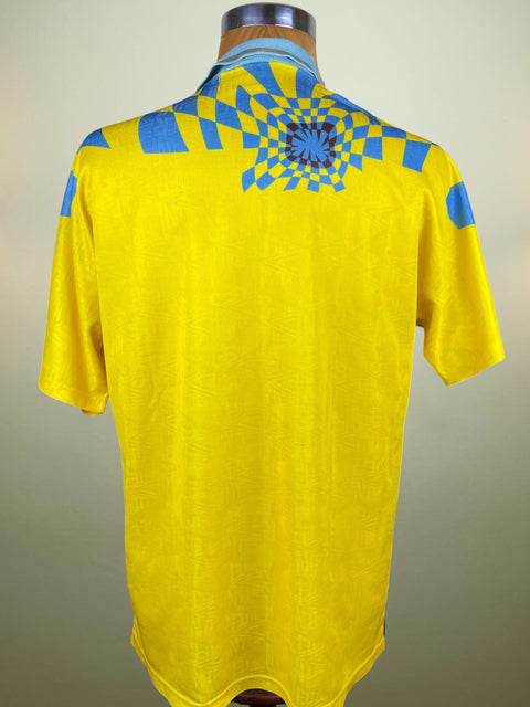 Yellow Inter Milan 1992 Third shirt with blue patterns on a mannequin against a beige background