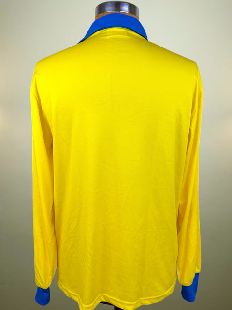 A bright yellow long-sleeve shirt shown from the back on a mannequin, featuring a contrasting royal blue collar and cuffs.