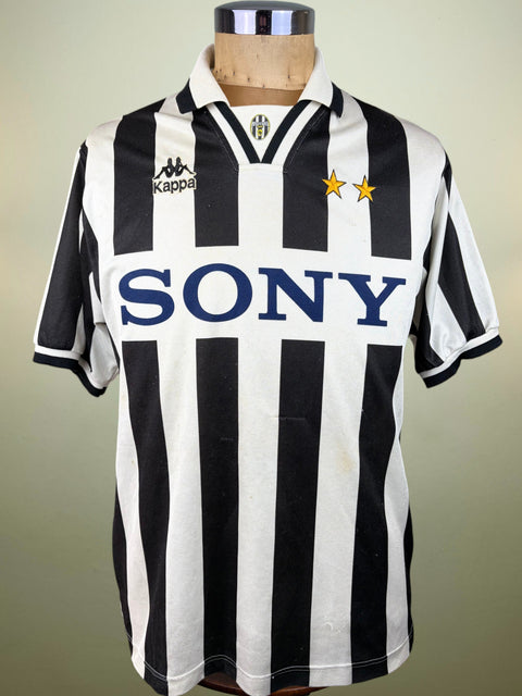 Vintage Juventus home soccer jersey with black and white vertical stripes, featuring the Kappa logo on the right chest, two gold stars on the left chest, and a large 'SONY' sponsor logo across the front. The jersey is displayed on a wooden mannequin torso against a neutral light green background.