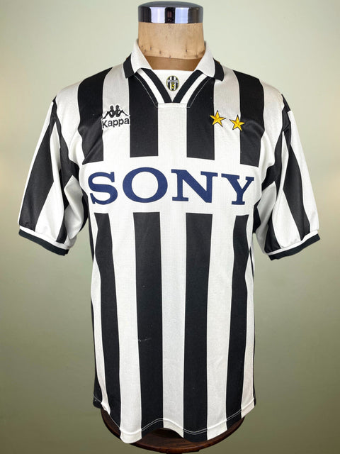 Black and white striped Juventus jersey with 'Sony' and 'Kappa' logos on a mannequin against a neutral background