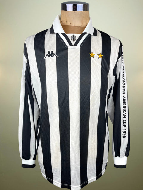 A vintage long-sleeve Juventus football jersey with black and white vertical stripes, featuring the Kappa logo on the chest, two gold stars, and 'SOUTH AMERICAN CUP 1996' printed down the sleeve, displayed on a mannequin torso.