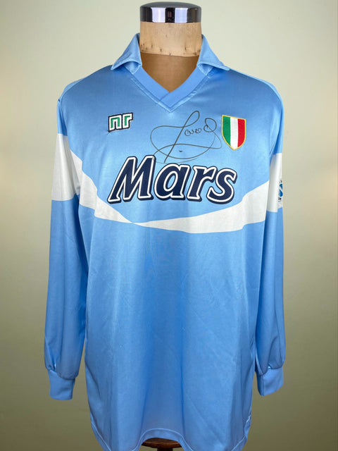 Blue Napoli home jersey from 1990-91, made by Ennerre with 'Mars' branding and signed by Careca on the chest on a mannequin against a beige background