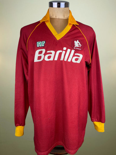 Red AS Roma 1987-88 Ennerre Home jersey with yellow accents, Barilla sponsor across the chest and Lupetto badge on a mannequin against a neutral background