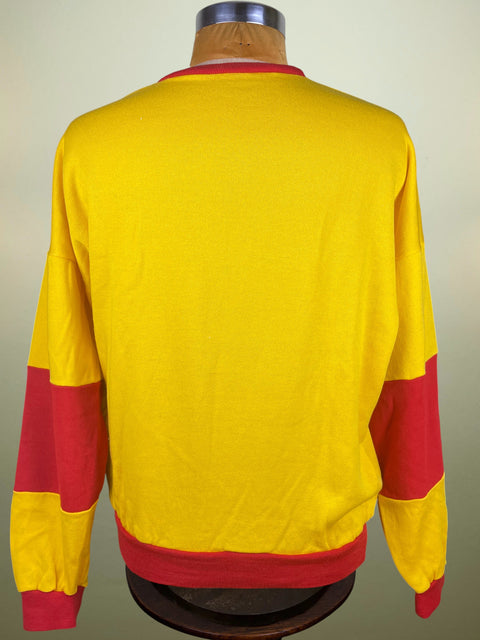 A yellow long-sleeve crewneck sweatshirt with red color-blocked sections on the sleeves and hem, displayed on a wooden dress form from the back.