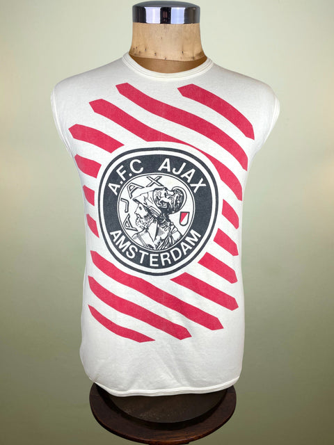 White sleeveless shirt with red stripes and AFC Ajax logo on a mannequin against a beige background