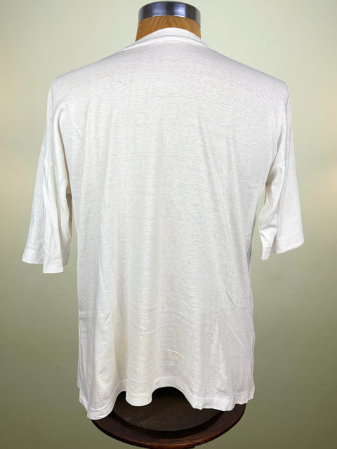 A white short-sleeve t-shirt displayed on a wooden dress form mannequin, viewed from the back against a light beige background.