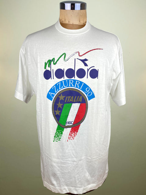 White t-shirt with Diadora logo and Italian flag design on a mannequin against a beige background