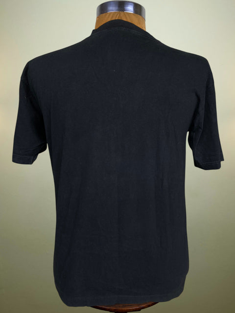 A black short-sleeve t-shirt displayed on a wooden dress form mannequin against a light beige background.
