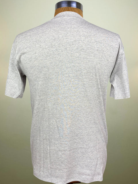 A light heather gray short-sleeve t-shirt displayed on a wooden dress form mannequin, showing the back view against a soft beige gradient background.