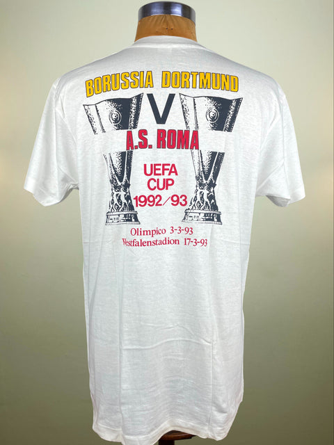 White t-shirt with Borussia Dortmund and A.S. Roma UEFA Cup 1992-93 design on a mannequin against a beige background.