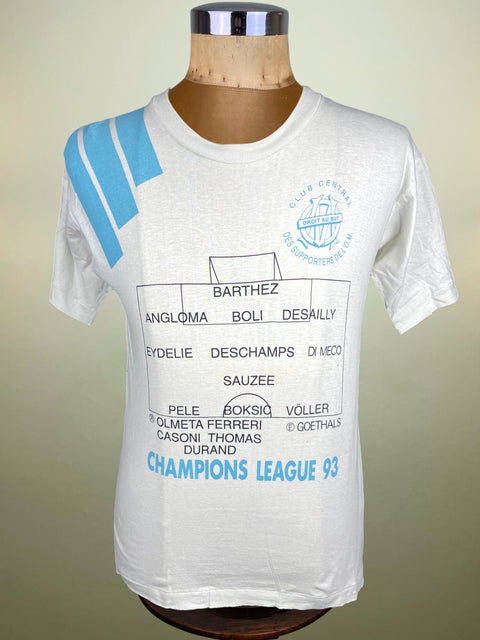 White t-shirt with blue graphics and text on a mannequin against a beige background