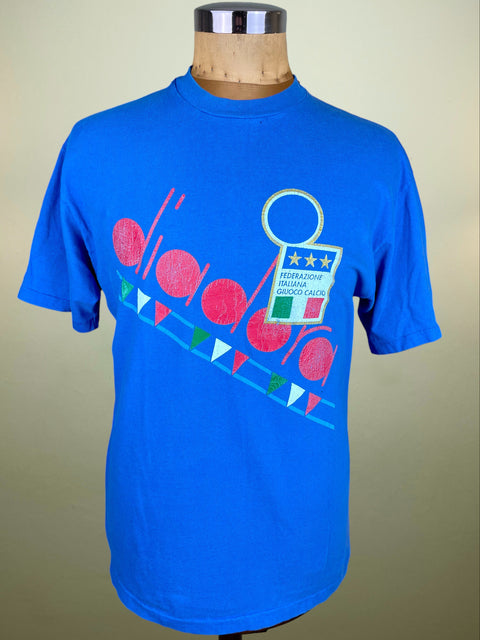 Blue t-shirt with colorful graphic on a mannequin against a beige background