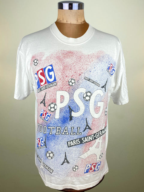 White t-shirt with PSG logos and designs on a mannequin against a beige background