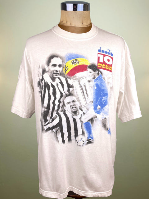 White t-shirt with soccer-themed graphic on a mannequin against a green background