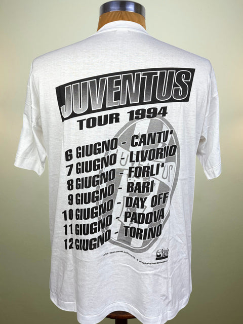 White short-sleeve T-shirt displayed on a mannequin torso, showing the back with a large black and gray Juventus Tour 1994 graphic print.