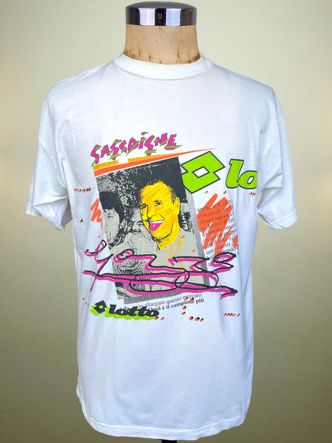 A white short-sleeve graphic Lotto t-shirt displayed on a wooden dress form mannequin against a beige gradient background. The shirt features a colorful pop-art style graphic with the text 'Gascoigne' in vibrant pink, green, orange, and yellow.