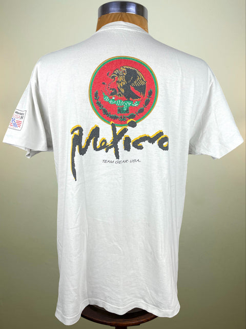 White t-shirt with a logo and text on the back, displayed on a mannequin against a plain background.