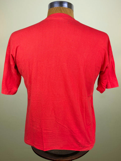 A bright red short-sleeve shirt shown from the back on a dress form mannequin against a light beige background.