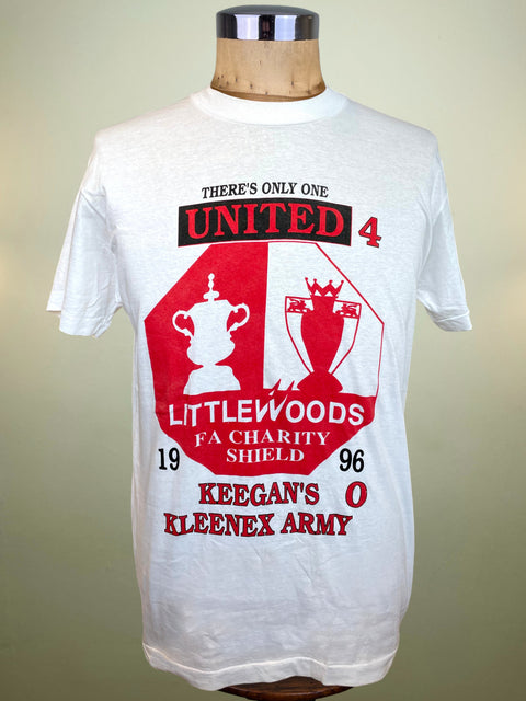 A white short-sleeve graphic T-shirt displayed on a wooden dress form mannequin against a plain beige background. The shirt features a large red and black graphic print on the front with the text 'THERE'S ONLY ONE UNITED 4 LITTLEWOODS FA CHARITY SHIELD 1996' and 'KEEGAN'S O KLEENEX ARMY'.