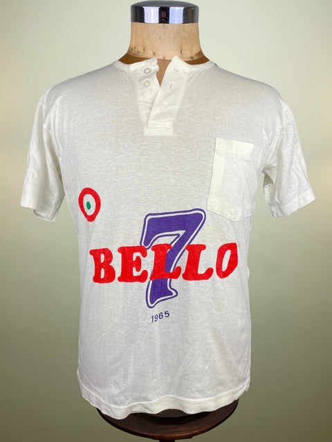 White shirt with 'Bello 7' print on a mannequin against a beige background