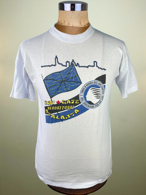 White t-shirt with graphic design on a mannequin against a beige background