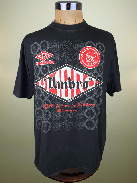 Black Ajax t-shirt with Umbro logo on a mannequin against a beige background