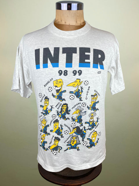 White t-shirt with cartoon characters and 'INTER' text on a mannequin against a beige background
