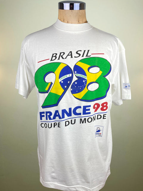 White t-shirt with 'Brasil 98 France Coupe du Monde' design on a mannequin against a beige background