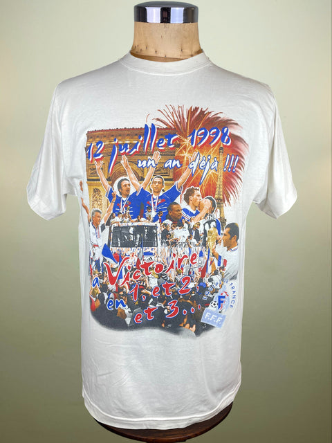 White t-shirt with a colorful graphic on a mannequin against a beige background