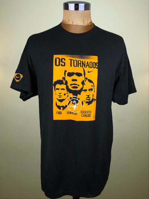 Black Nike Os Tornados t-shirt with yellow graphic design and pictures of Ronaldo, Figo and Roberto Carlos on a mannequin against a beige background