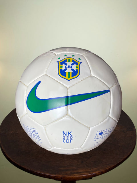 White soccer ball with Nike and CBF logos on a wooden stand