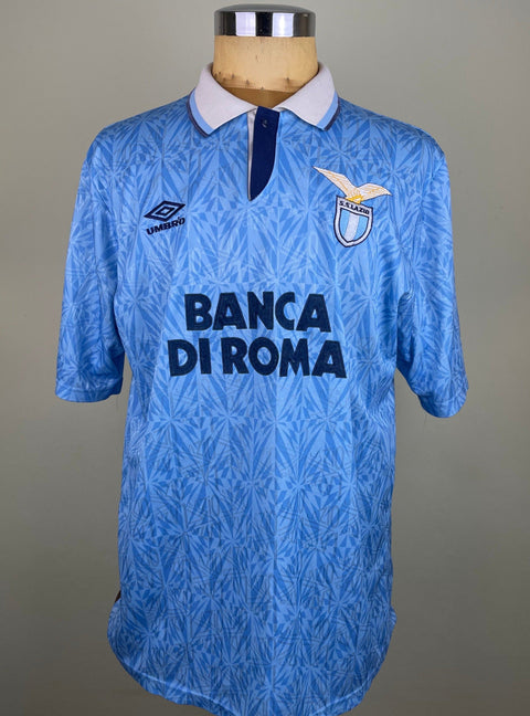 A blue and white striped Lazio 1992-93 home jersey featuring an Umbro logo on the chest the Banca Di Roma sponsor in flock.
