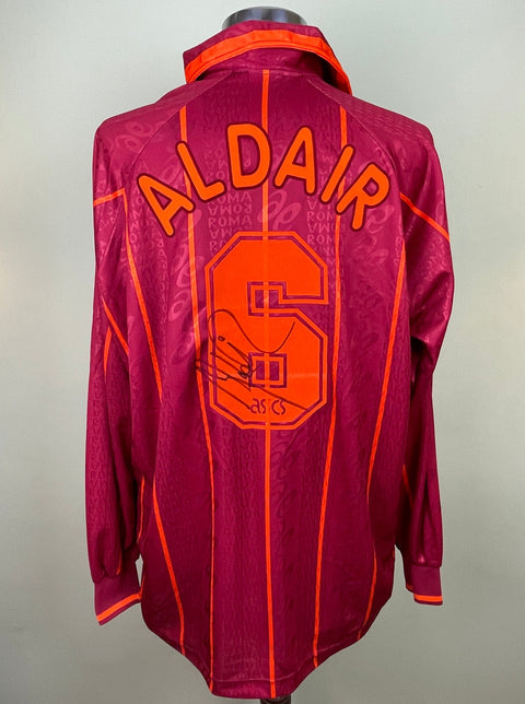 Maroon AS Roma 1996/97 home shirt, long sleeves, ALDAIR 6 in orange flock across the back, with his signature on the number 6 . Match-worn and signed by Aldair.